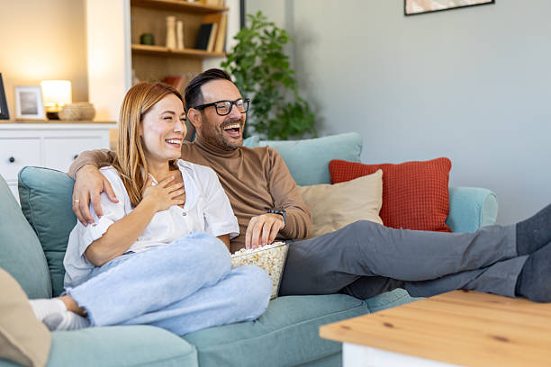 istock Couple enjoys popcorn and laughter on couch in cozy setting 2234399967