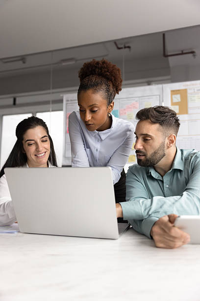 istock Group of multiethnic professionals gathered together in office using laptop 2234401835