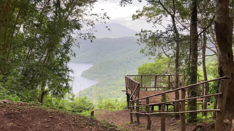 Horizontal video of a wooden viewing platform with no people, from a distance you can see the Mombacho volcano and Laguna de Apoyo, from Catarina, Nicaragua.