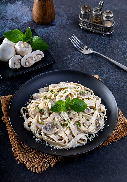 istock Pasta carbonara cream sauce with mushroom in a black plate 2234406437