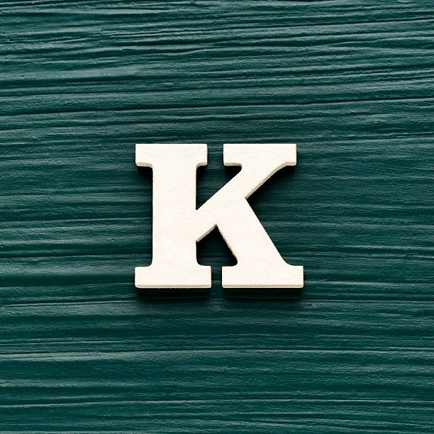 Capital letter K, White letter on a rustic dark green background