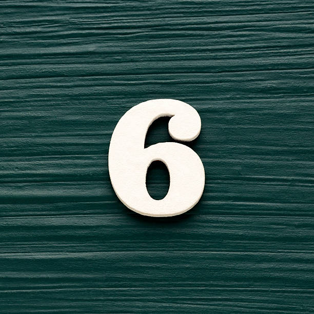 istock Number 6 white piece on a rustic dark green background 2234408757