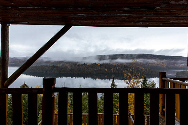 istock Rustic Cabin Balcony Overlooking Misty Lake and Pine Forest Hills 2234409239