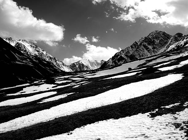 Cold snowy mountain landscape at sunset. Panoramic view of snowy mountain peaks and slopes of North Chuyskiy ridge at sunset. Russia, Siberia, Altai mountains.