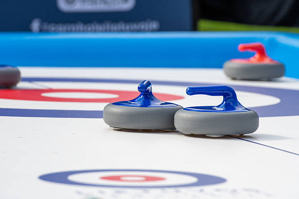 istock Several curling stones with red and blue handles are positioned on a recreational curling sheet 2234420699