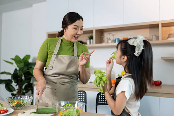 istock Healthy Cooking: Mother and Daughter Enjoying Fresh Greens 2234423303
