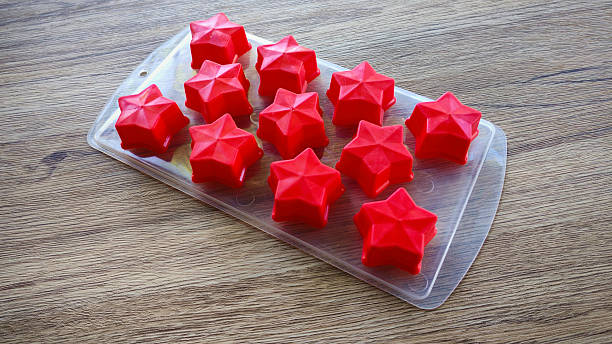istock Empty red silicone star molds in a transparent tray on a wooden table 2234424078