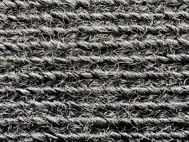 istock Extreme close-up of a black textured fabric, revealing a horizontal ribbed pattern with visible, fuzzy wool fibers in a detailed macro view. 2234424108