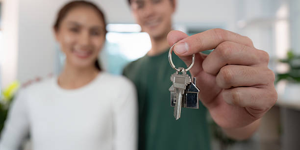 istock New homeowners celebrating with keys, symbolizing achievement 2234424752