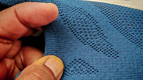 istock Textured Blue-Gray Woven Mesh Fabric Held by Hands, Highlighting a Detailed Diamond Pattern on a Modern Shoe Material. 2234425105