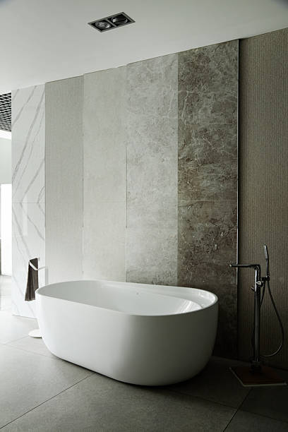 istock Contemporary Bathroom Featuring Oval Bathtub and Textured Stone Wall Panels 2234427692