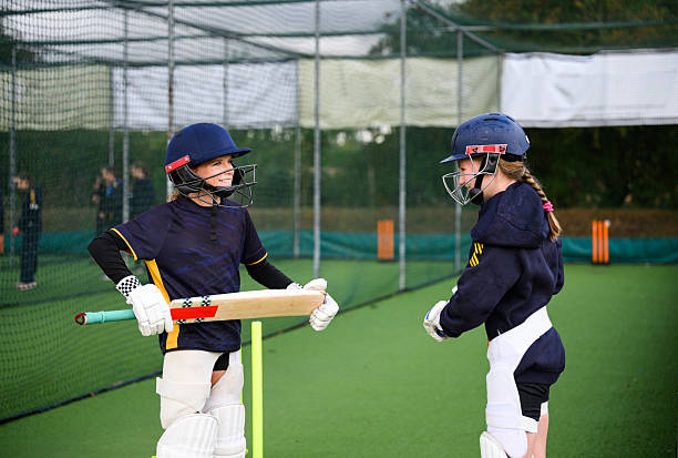 istock Young female batsmen warming up before practice in nets with teammates 2234429209