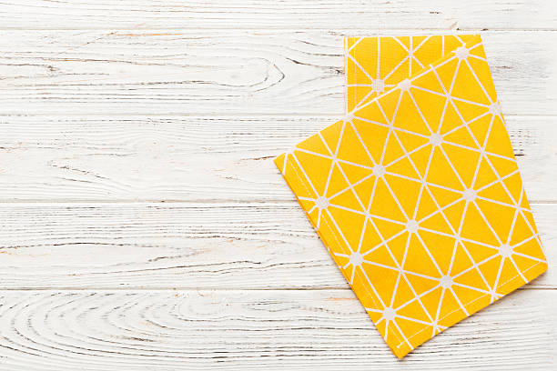 istock top view with yellow empty kitchen napkin isolated on table background. Folded cloth for mockup with copy space, Flat lay. Minimal style 2234434099