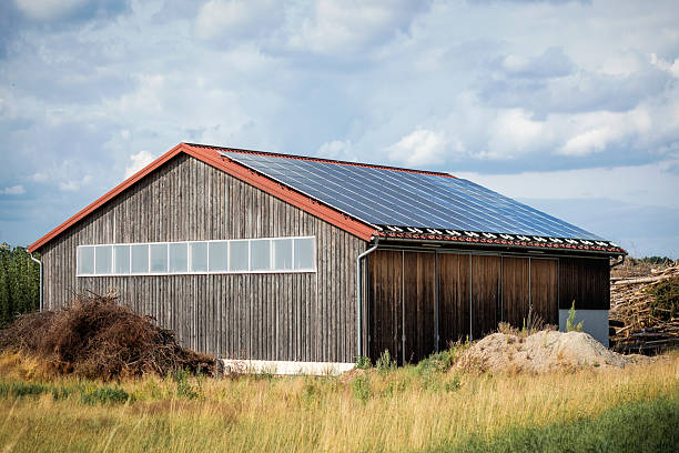 Barn or Shed with Solar Panels Roof Outdoor. Hangar Agricole Hay Storage with Solar Panel Technology.