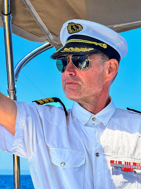 Skipper dressed like an admiral pointing with arm.