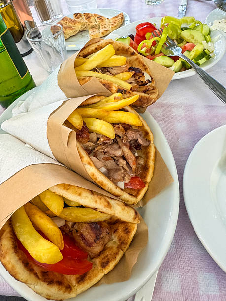 Delicious Greek gyros pitas with different ingredients and Greek salad.