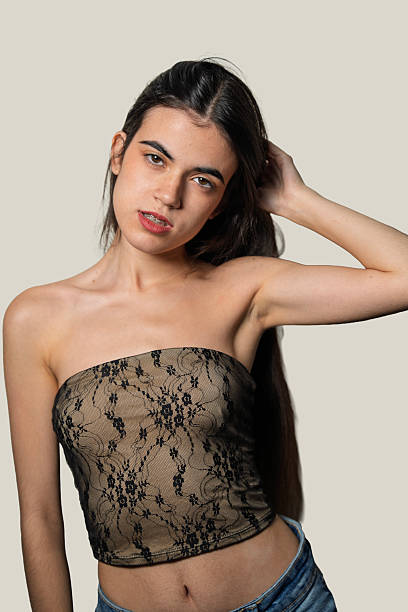 istock Young woman touching hair and posing in studio 2234438145