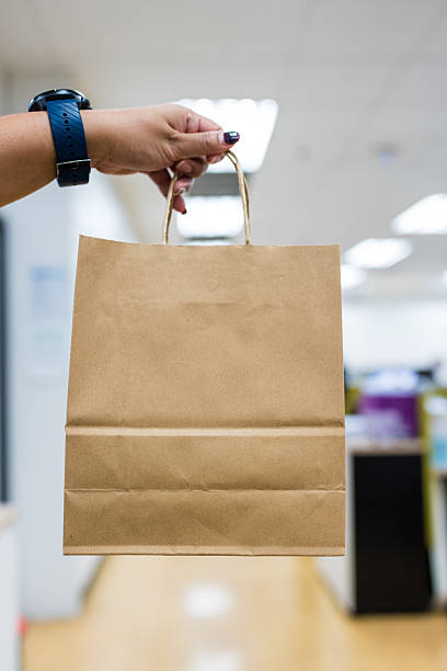 Woman holding empty brown paper bag
