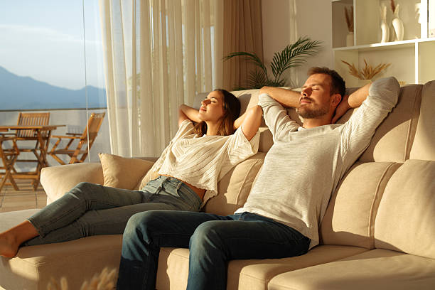 istock Relaxed couple resting on a couch at home at sunset 2234441275