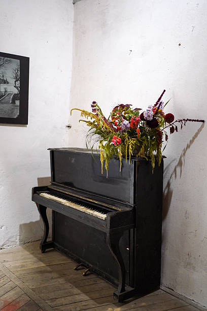 istock Old upright piano with wild flower arrangement in a rustic interior 2234442119