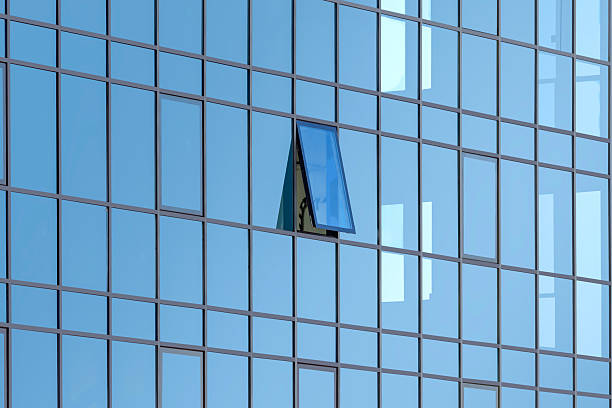 istock The blue glass wall of a modern building with one open window 2234442724