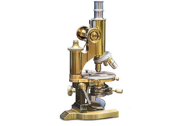 istock Vintage brass microscope on stand in a pharmacy, against a light grey background, goldish-brown metal, diffuse lighting from above a 2234443546