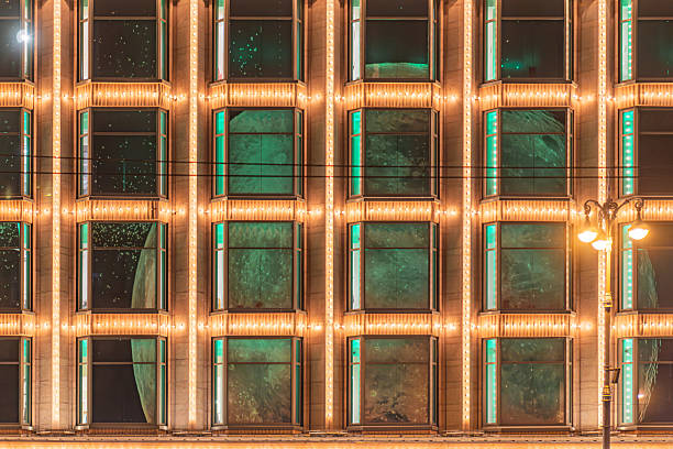 Nighttime scene of an illuminated building with translucent windows displaying Christmas decorations and New Years concepts a