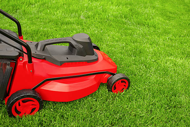 istock A red and black lawn mower stands on the grass. 2234448561