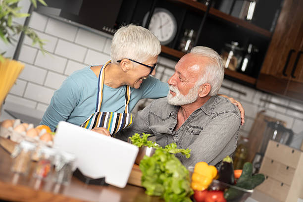 istock Mature couple following recipe on digital tablet while preparing lunch in the kitchen 2234450852