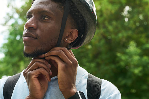 istock Black Man Fastening Helmet Strap Outdoors before Cycling 2234452412