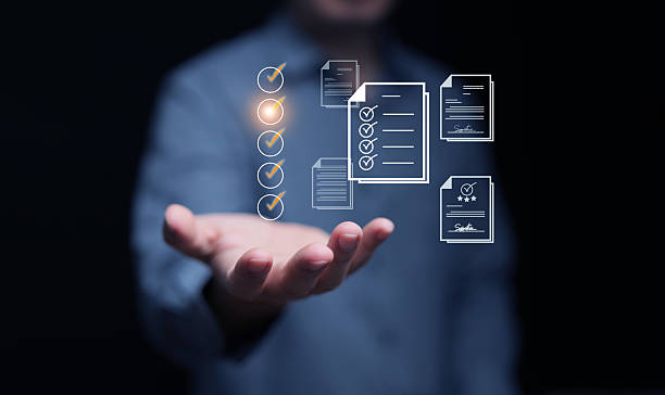 istock Business checklist with hand holding digital documents and glowing check marks, symbolizing task management, workflow efficiency, and productivity strategy in corporate solutions. 2234457707