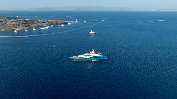 A serene aerial view of yachts scattered across the clear blue waters of the Mediterranean, showcasing luxury and relaxation.