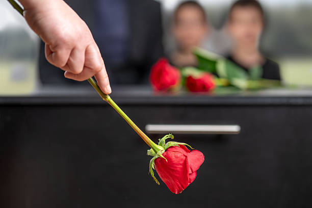 istock Sad woman leaving a rose over the coffin 2234460989