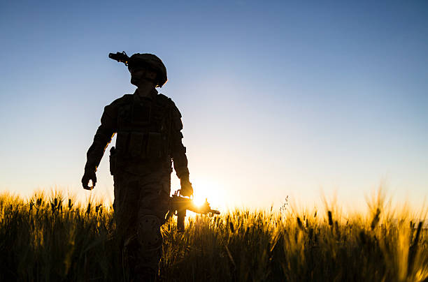 Soldier walking in battlefield at sunset
