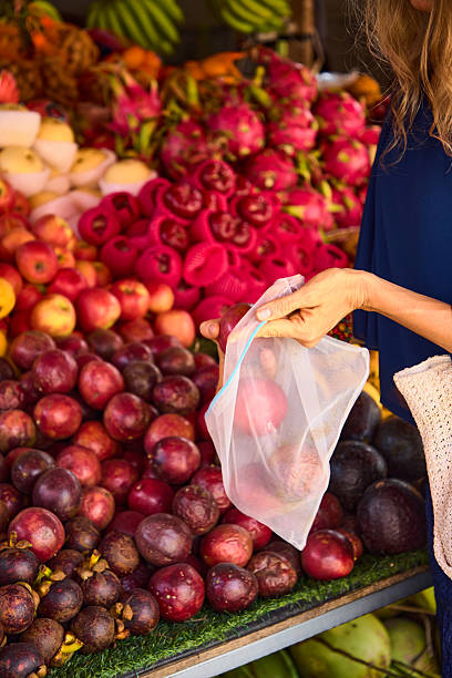 Hand selecting fresh fruits at a vibrant farmers market display