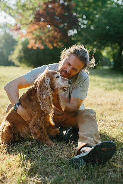 istock Man cuddling his dog in a sunny park 2234468690
