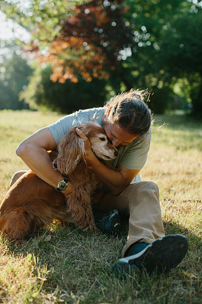 istock Man hugging his dog in the park 2234468694