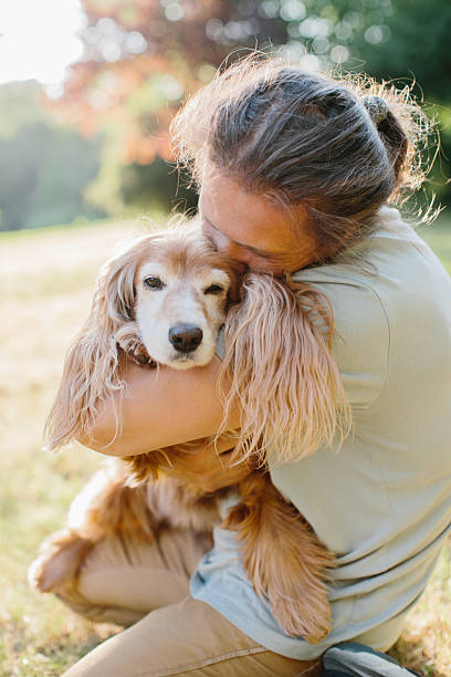 istock Woman embracing cocker spaniel with affection in green park 2234468850