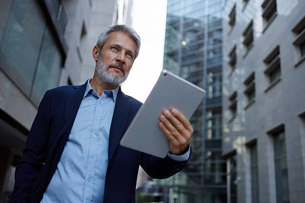 istock Professional businessman navigating urban landscape, working on digital tablet while walking, embodying modern corporate connectivity 2234469881