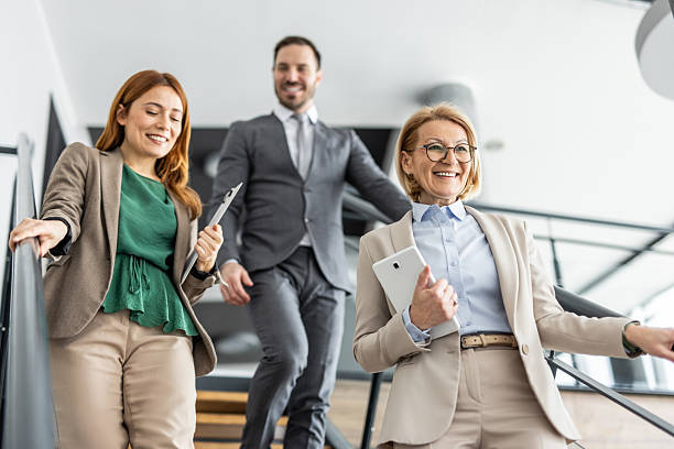 istock Businesspeople walking up stairs in modern office 2234471809