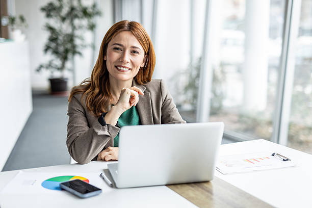 istock Businesswoman smiling while working on laptop in office 2234472989