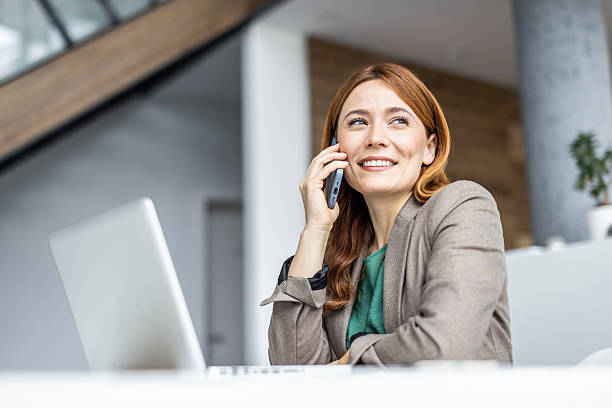 istock Businesswoman smiling while talking on phone in office 2234473073