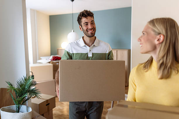 istock Happy couple carrying boxes while moving into their new home 2234474050