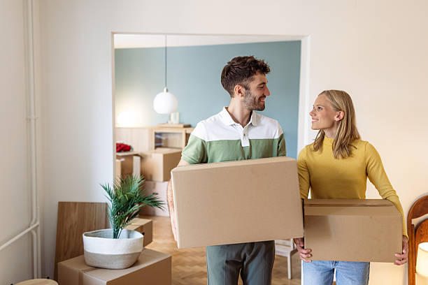 istock Young couple carrying boxes while moving into their new home together 2234474076