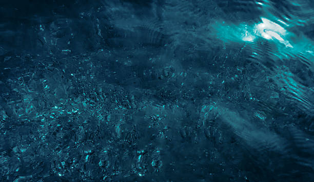 istock dark blue water on spotted sandy sea bottom background 2234474116