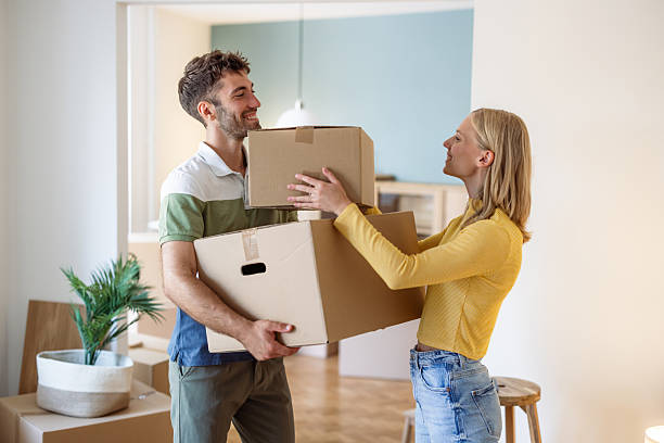 istock Young couple holding cardboard boxes together while moving into their new home 2234474313