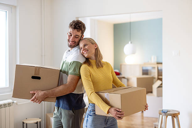istock Happy young couple holding moving boxes during a moving in process 2234474337