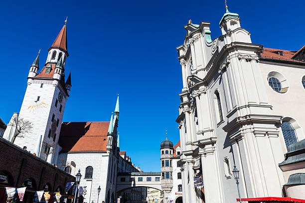 Munich, Germany - April 4, 2025: Facade of the Heilig Geist or Holy Ghost Church and Gothic town hall in Munich, Bavaria, Germany
