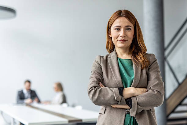 istock Confident businesswoman smiling with folded arms in modern office 2234477498