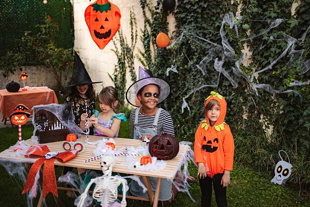 istock Children celebrating Halloween making decorations for a masquerade ball 2234477817